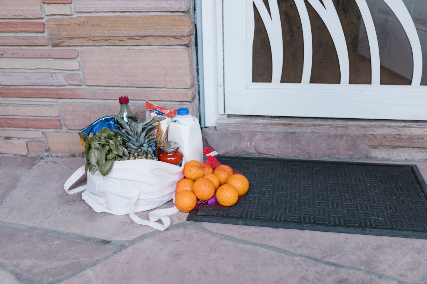 A bag of groceries waiting on a doorstep for pickup