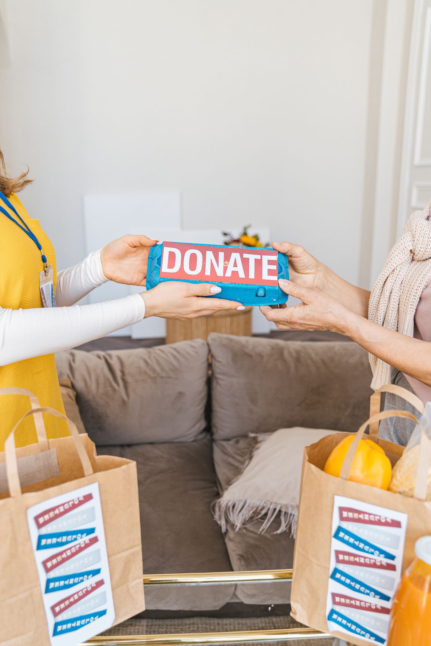 Two people handing over a donation of groceries