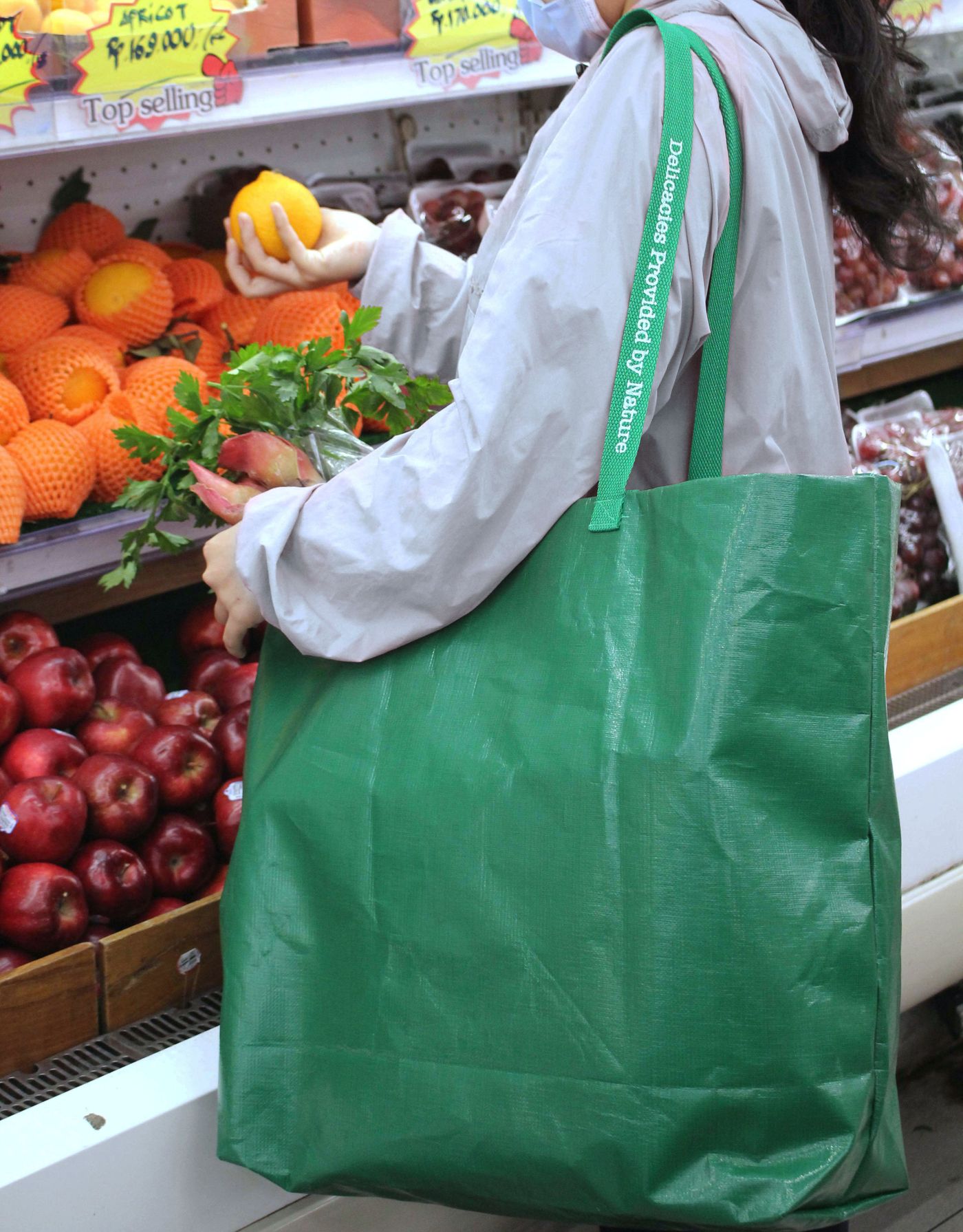 A green reusable grocery bag at the store